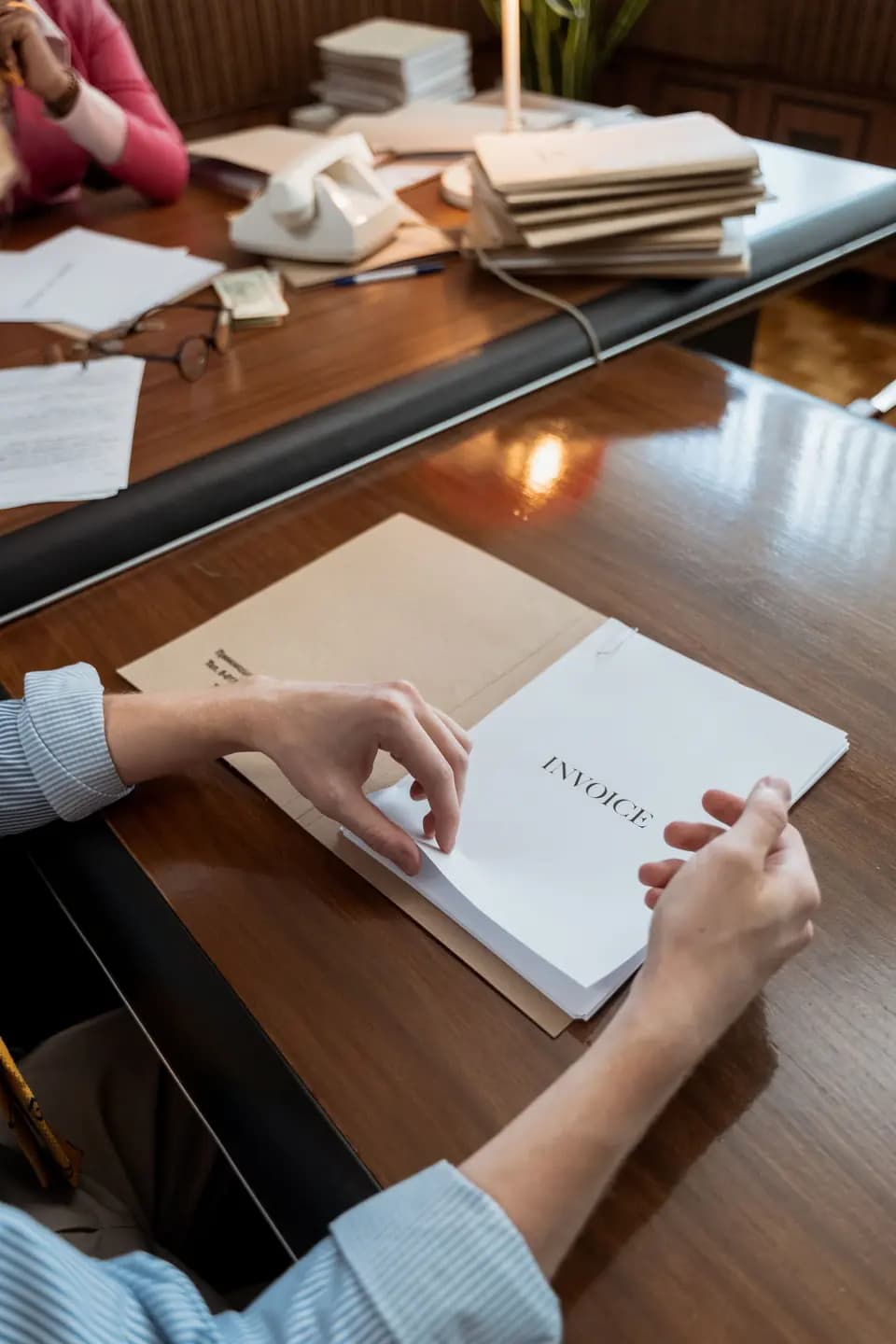 Invoices being sorted across an office desk