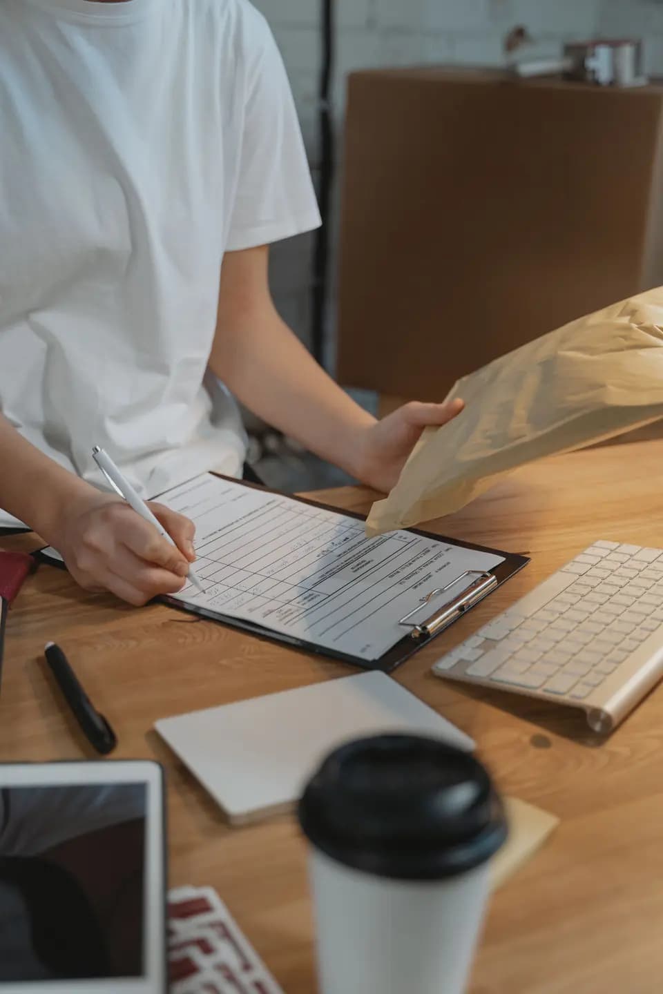 A form being completed on a clipboard beside a parcel