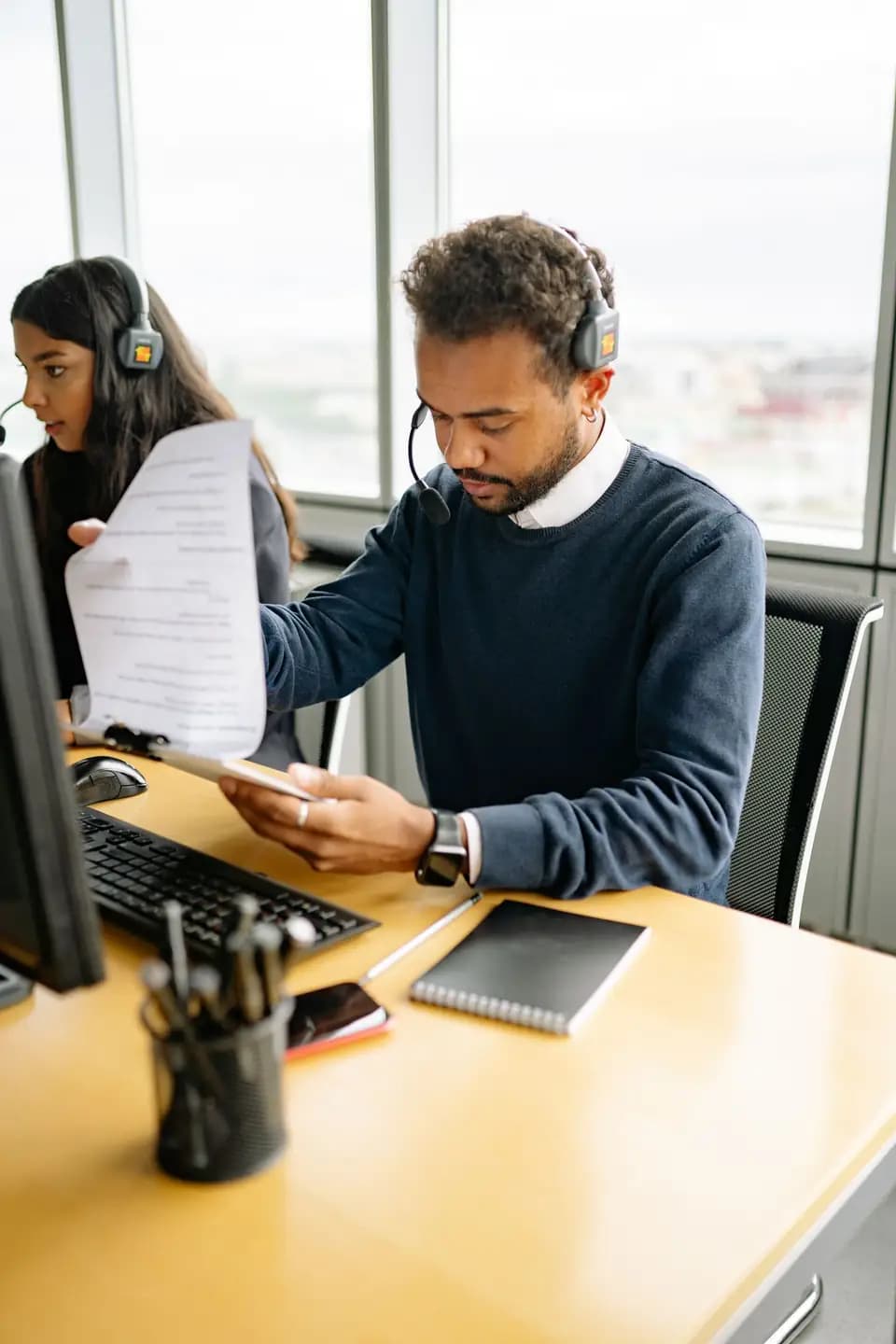 Two support staff going through a record on a clipboard