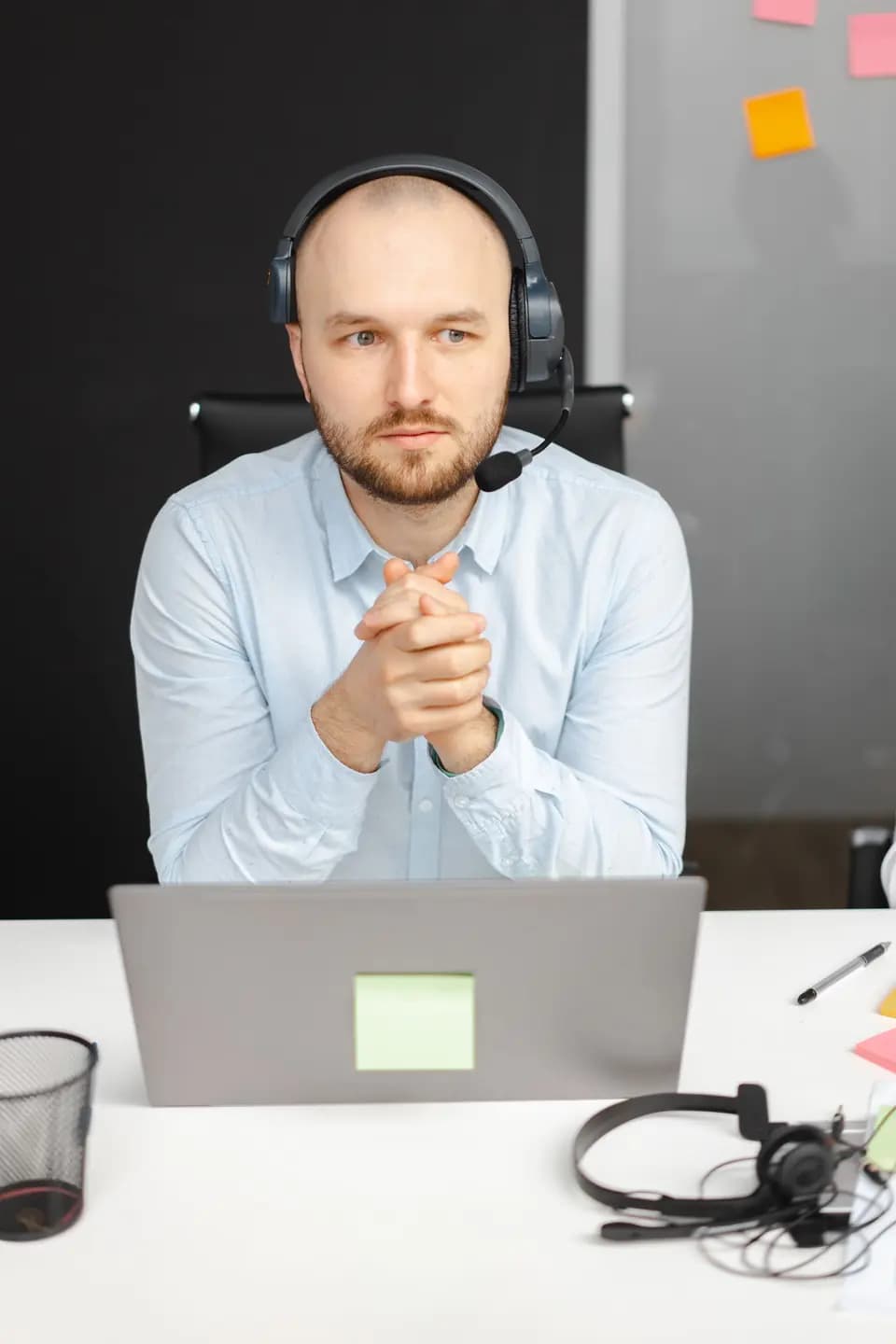 A support specialist in a headset working on a laptop