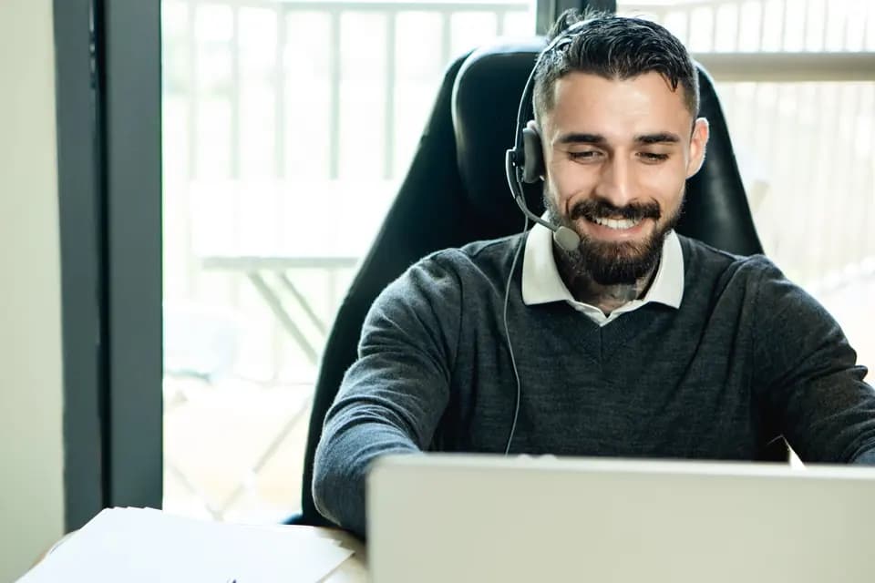 A support specialist in headphones working in an office