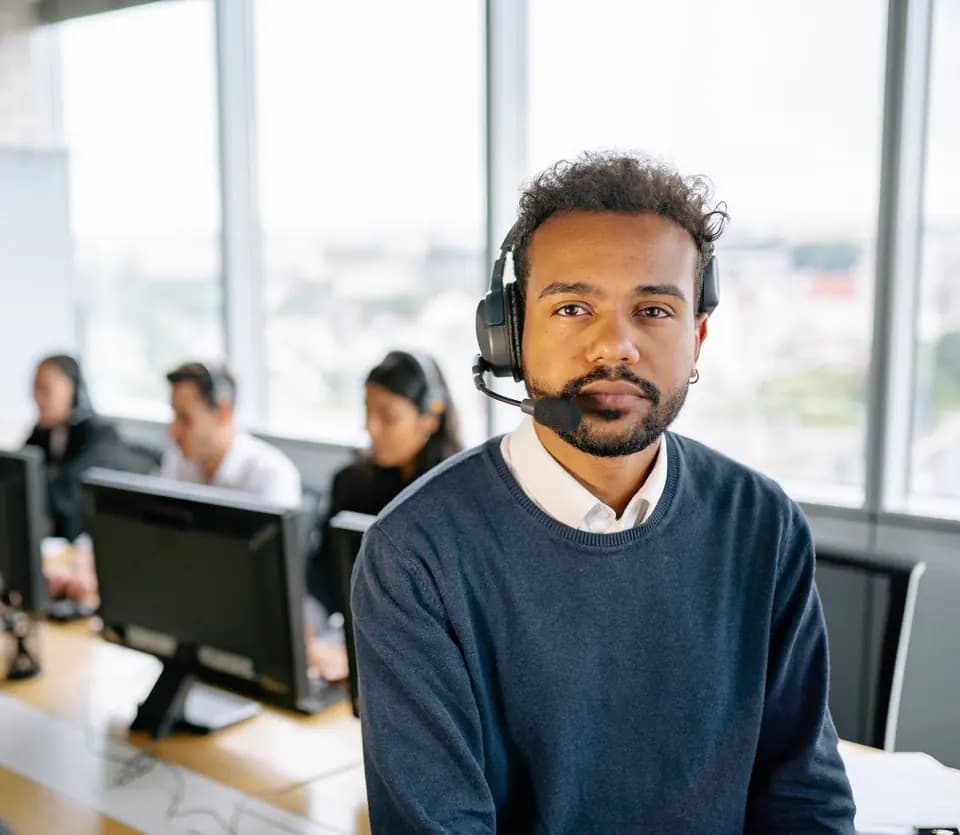 A support specialist in a headset in an open-plan office