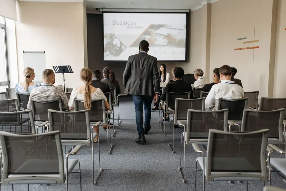 A presenter walking the aisle of a training room mid-session