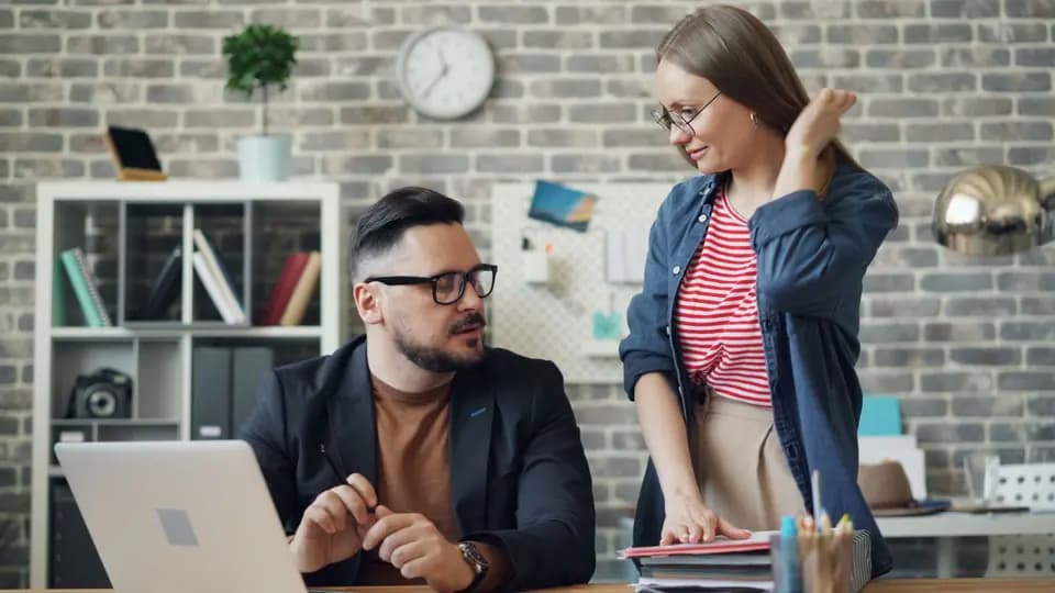 Two colleagues reviewing work at a desk