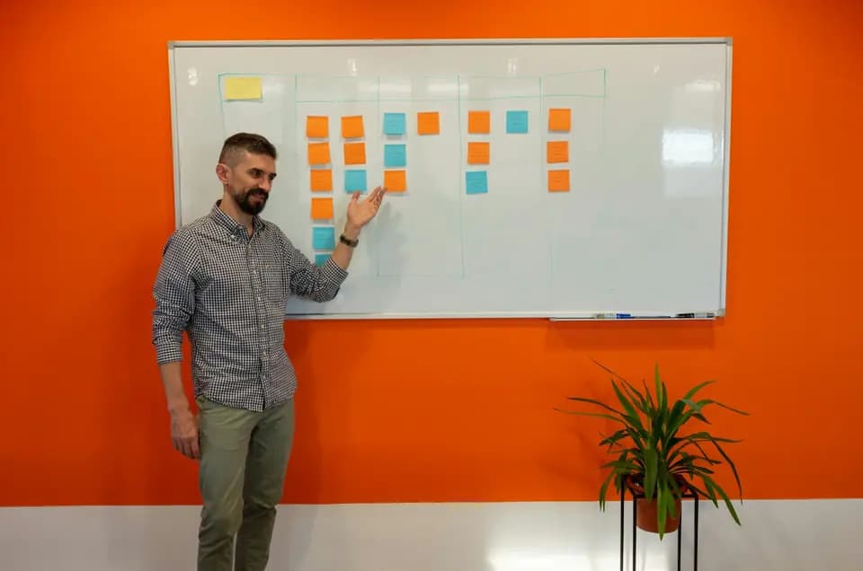 Someone standing at a whiteboard working through a problem