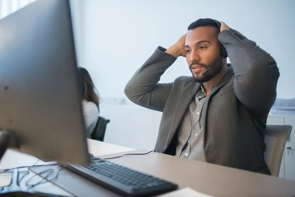 A support engineer in a headset concentrating on a problem on screen
