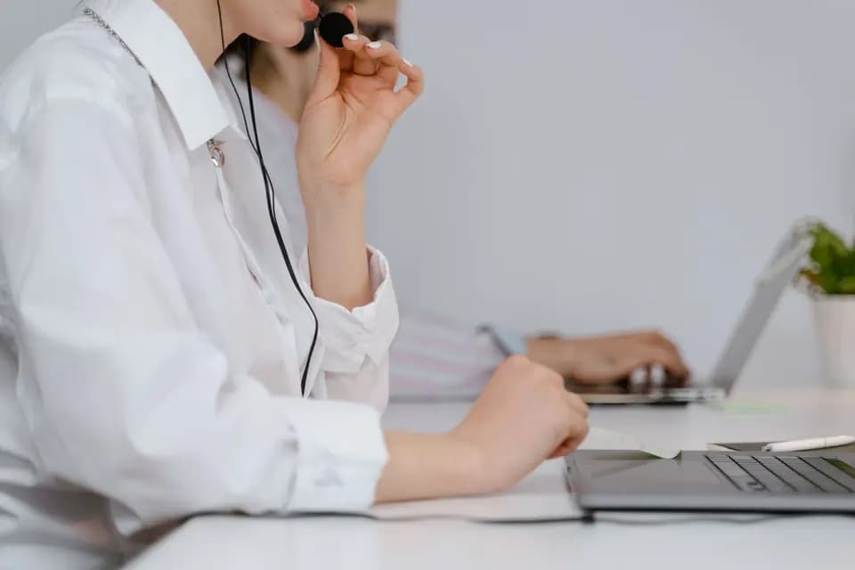 A support specialist speaking on a headset in an office
